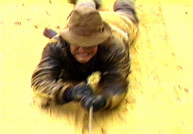 Chris Strompolos as Indiana Jones dragging behind truck.