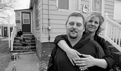 Eddie Buchanan and Mary Hurley in front of their Glace Boy home. Two of their three children, Brooklyn and Brady, sit on the steps to their left. Photo courtesy Nance Ackerman/Hot Docs.