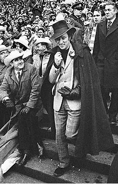 Sly guy: Prime Minister Pierre Trudeau walks down the grandstand steps to
				present the 1970 Grey Cup trophy. CP Photo/Peter Bregg.