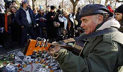 A ballad for John: Amos Wengler sings and plays a guitar with fans at the "Imagine" memorial dedicated to the late Beatle John Lennon, in the Strawberry Fields section of New York's Central Park. Photo Stan Honda/AFP/Getty Images.