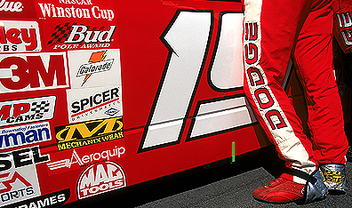 More brands per square inch than Times Square: Casey Atwood stands near his sponsor's logos before the Protection One 400 in Kansas City, Kansas. Photo Jonathan Ferrey/Allsport. 